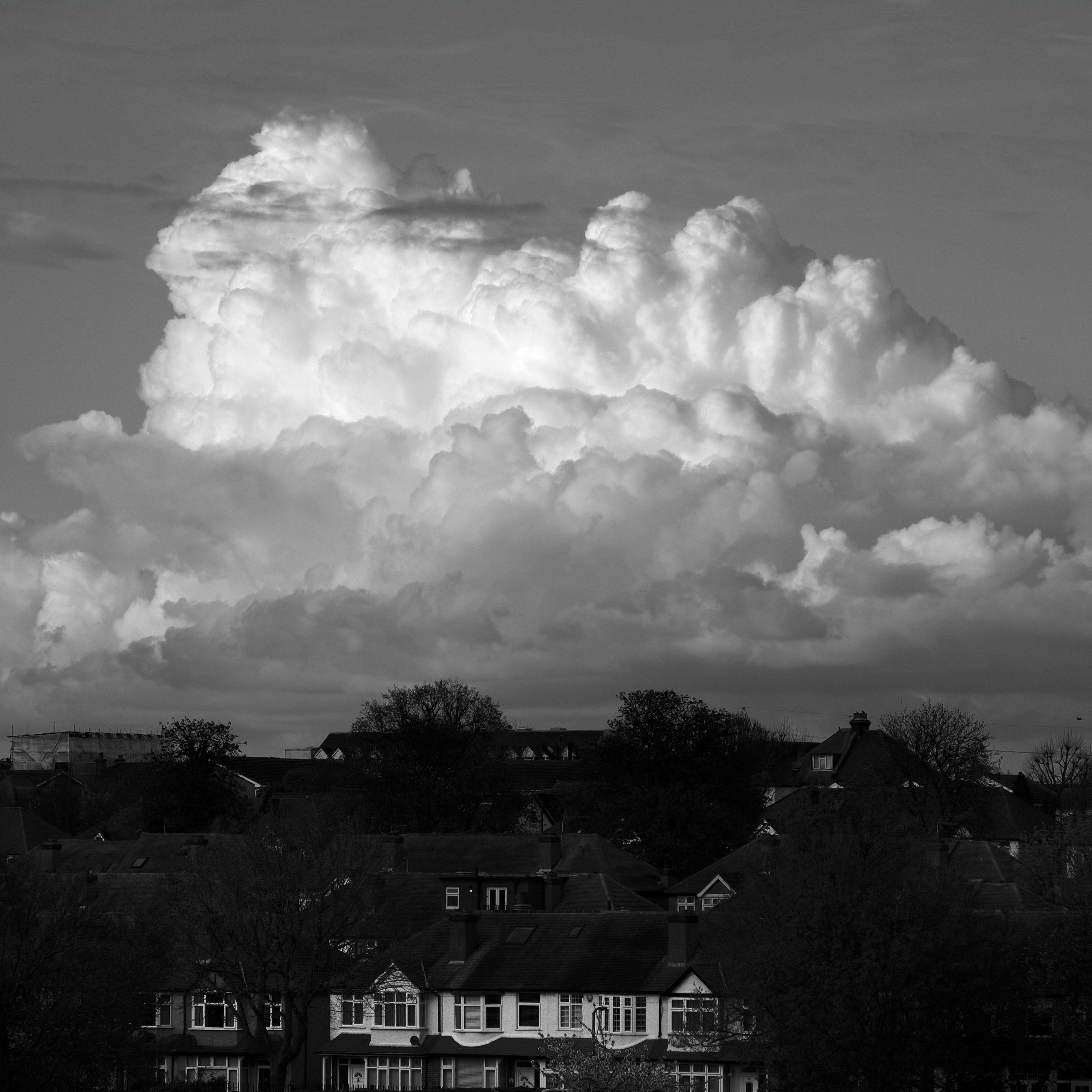 Suburban houses with dramatic white clouds overhead